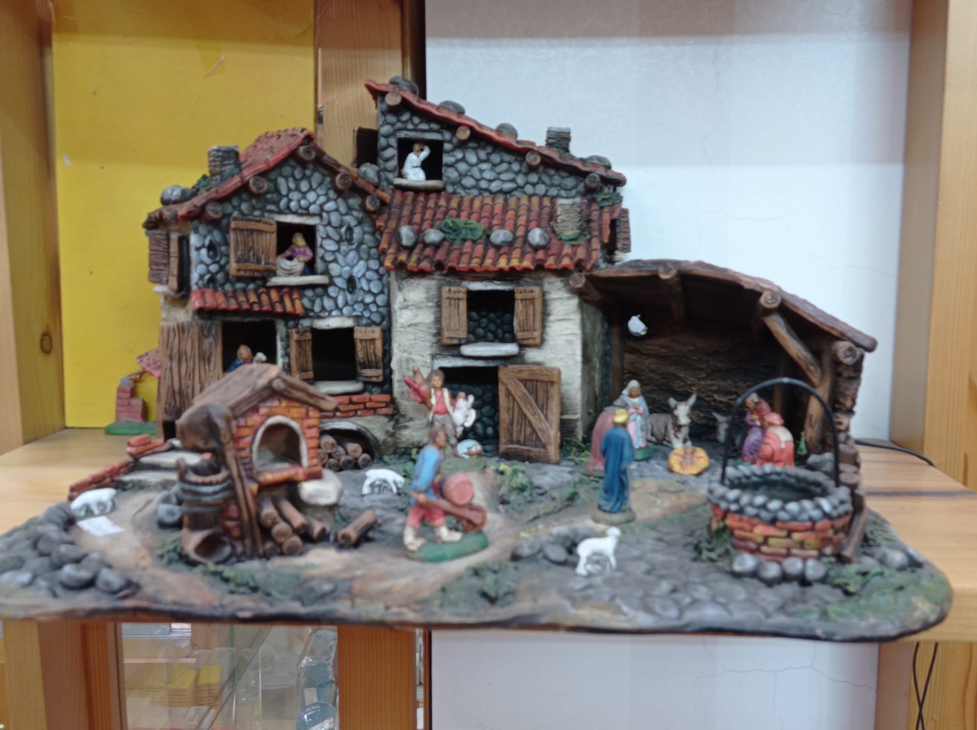 Presepe in ceramica con case, personaggi e scena rurale